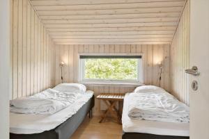 two beds in a room with a window at 374-Harboore-Fourmivej-15 in Harboør