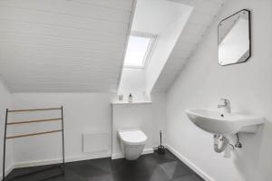 a white bathroom with a sink and a toilet at 526-Lemvig-Rubyvej-21 in Lemvig +23 photos