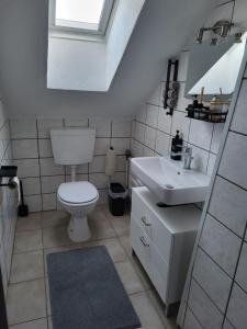 a bathroom with a toilet and a sink at Appartement Ferienwohnung in Hövelhof +4 photos