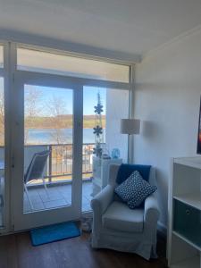 a living room with a chair and a sliding glass door at Modernes Apartment mit Pool und Sauna in Möhnesee