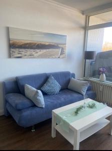 a blue couch and a coffee table in a living room at Modernes Apartment mit Pool und Sauna in Möhnesee