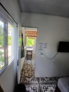 a room with a hallway with a table and a window at Pousada Unidos in Jijoca de Jericoacoara