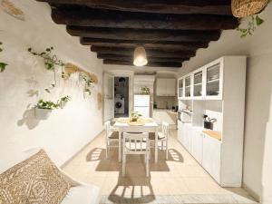 a kitchen and dining room with a table and chairs at Kalma - at the picturesque Via Stretta in Cagliari