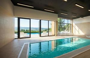 a swimming pool in a building with a large window at Moje Miejsce Polanica-Zdrój in Polanica-Zdrój