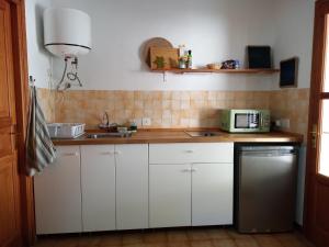 a kitchen with white cabinets and a sink and a microwave at Residence Can Confort Formentera in Sant Francesc Xavier +27 photos