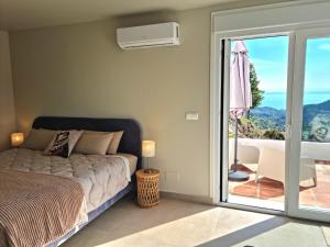 a bedroom with a bed and a sliding glass door at Casa La Jolla B&B in Cómpeta +68 photos