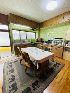 a kitchen with a table and chairs in it at 与那国島一棟貸切宿はいぬきち in Yonaguni