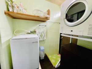 a small kitchen with a washing machine and a sink at 与那国島一棟貸切宿はいぬきち in Yonaguni