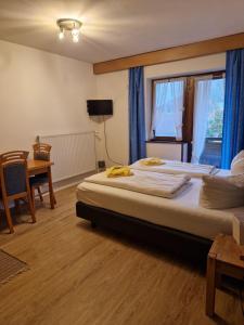 a bedroom with a bed and a table and a window at Ferien- und Reiterhof Ochsenkopf in Missen-Wilhams