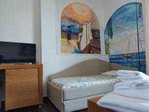 a bedroom with a bed and a tv and a painting at Villa Nettuno in San Menaio