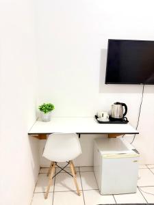 a white desk with a tv on a wall at Bonno Guest Suite in Gaborone