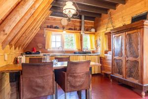 a kitchen with wooden walls and a wooden table and chairs at Unieke plaggenhut in Drenthe met bedstee & uitzicht op wijngaard in Ruinerwold