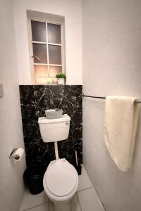 a small bathroom with a toilet and a window at Bonno Guest Suite in Gaborone