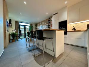 a kitchen with a bar with stools in it at Appartement de Standing Plein Centre-Ville "L Atelier de Joss" in Bastogne