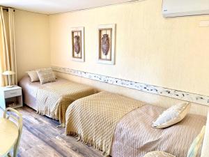 a room with two beds and a table and chairs at Apart hotel Entre Ríos ruta 5 Talca in Talca