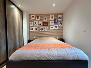 a bed in a bedroom with a wall with stickers at Appartement de Standing Plein Centre-Ville "L Atelier de Joss" in Bastogne