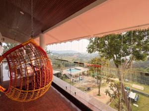 a swing hanging from a balcony with a view of a park at Riverside Resort Yelagiri in Yelagiri