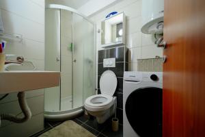 a small bathroom with a toilet and a sink at Stan na dan DM Uzice in Užice +10 photos
