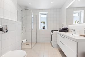 a white bathroom with a shower and a toilet at Svolvær Panorama City Suite in Svolvær