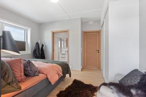 a bedroom with a bed with an orange blanket at Svolvær Panorama City Suite in Svolvær