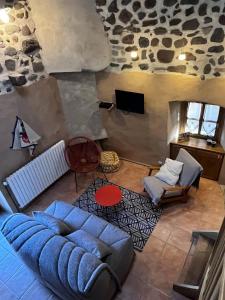 a living room with a blue couch and a tv at Le Petit Moras in Chomérac