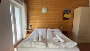 ein Schlafzimmer mit einem Bett, auf dem zwei Handtücher liegen in der Unterkunft Hotel Al Pelmo in Pieve di Cadore