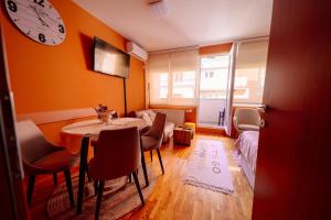 a room with a table and chairs and a clock on the wall at Stan na dan DM Uzice in Užice