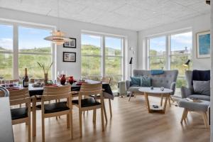 a dining room and living room with a table and chairs at VK233-Harboore-Doblervej-83 in Harboør +26 photos