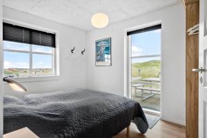 a bedroom with a bed and a large window at VK233-Harboore-Doblervej-83 in Harboør