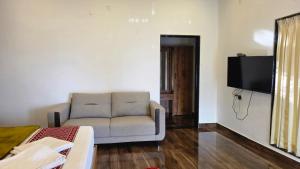 a living room with a couch and a flat screen tv at Riverside Resort Yelagiri in Yelagiri +38 photos