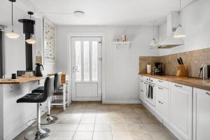 a kitchen with white cabinets and a table and chairs at 704-Thyboron-Kirkevej-6 in Thyborøn +18 photos