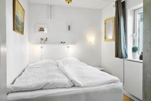a white bedroom with a large white bed in it at 704-Thyboron-Kirkevej-6 in Thyborøn