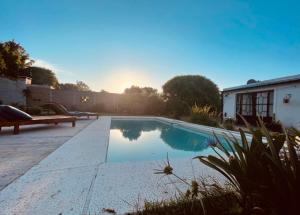a swimming pool with a bench next to a house at Casa Sua in Victoria