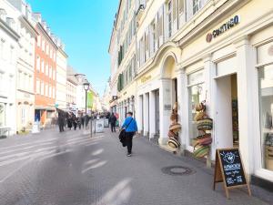a person walking down a street in a city at Historisches Altstadt-Juwel - Ruhige Top-Lage in Uninähe in Heidelberg