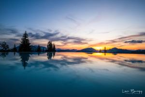 a large body of water with a sunset in the background at Tihuta Chalet in Piatra Fantanele