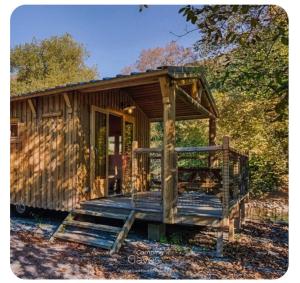 a small wooden cabin with a porch and a deck at Cabane bois insolite vue montagne piscines famille in Laruns +6 photos