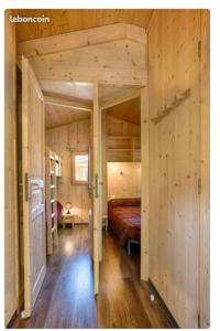 a bedroom with a bed in a wooden house at Cabane bois insolite vue montagne piscines famille in Laruns