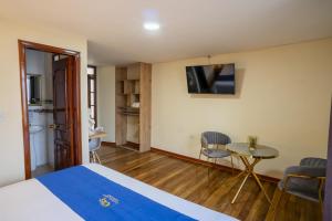 a room with a bed and a table and a tv at Hotel Catedral Boutique Loft in Pasto