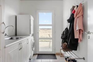a kitchen with white cabinets and a sink and a window at 519-Lemvig-Gaskaervej-95-h in Lemvig +21 photos