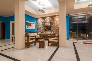 um átrio com paredes azuis, uma secretária e cadeiras em Antinea Suites Hotel & Spa em Kamari