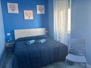 a blue bedroom with a bed and a chair at Tower casa vacanze 2 in Anzio