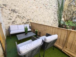 a patio with chairs and a table and a wall at Ressource in Casteljaloux