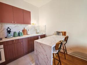 a kitchen with wooden cabinets and a marble counter top at Ressource in Casteljaloux