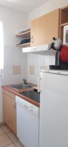 a white kitchen with a sink and a stove at Chez domi piscine résidence claire rive in Prayssac +6 photos