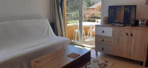 a bedroom with a bed and a tv and a table at Chez domi piscine résidence claire rive in Prayssac