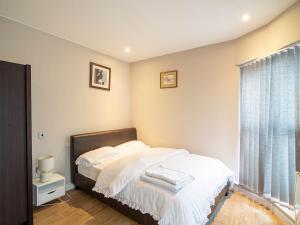 a bedroom with a bed with white sheets and a window at 1 Bed Cozy Flat City Center in Sheffield