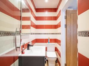 a bathroom with a red and white striped wall at 1 Bed Cozy Flat City Center in Sheffield