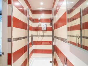 a bathroom with a red and white striped wall at 1 Bed Cozy Flat City Center in Sheffield