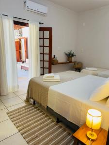 a bedroom with a bed and a table with a lamp at Jeromia Casa e Pousada in Rifaina