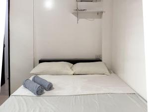 a bed in a white room with two pillows on it at Shiloh Homestay in General Luna +2 photos